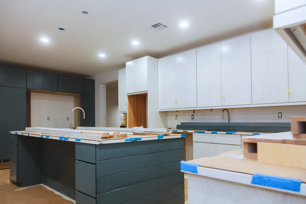 Kitchen cabinets and island masked with painter's tape before finishing